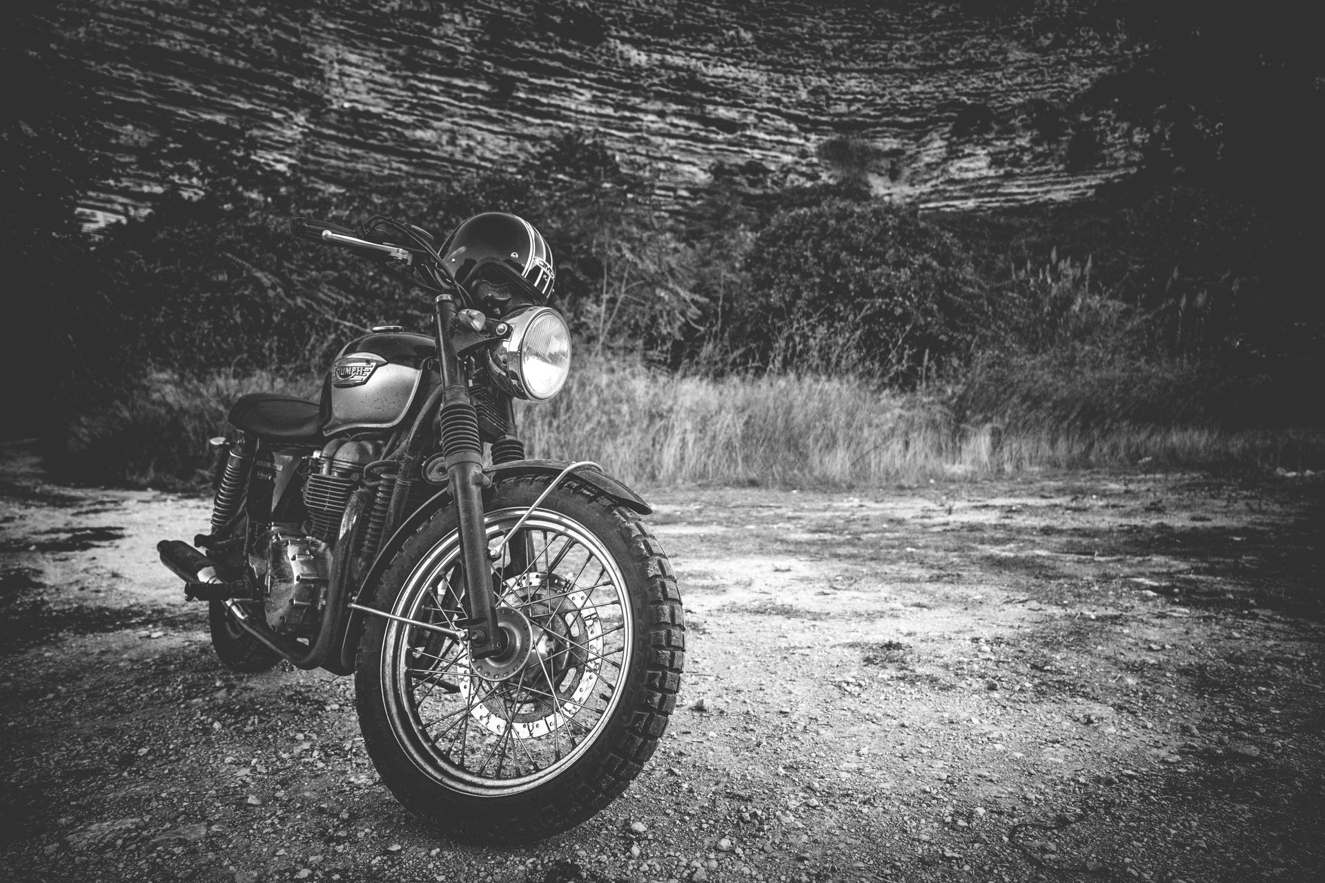 Triumph classique garée sur un chemin de terre, photographie en noir et blanc